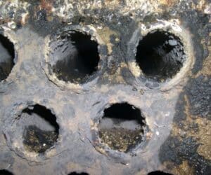 שיכבה עבה של משקעי קלציון קרבונט - אבנית נוצרו בתוך צינורות הברזל